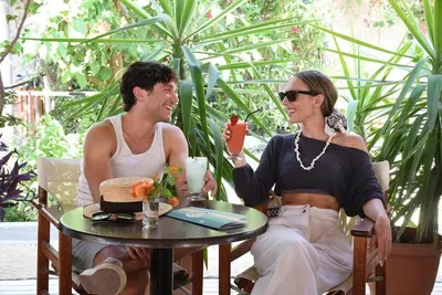 a man and woman sitting at a table with a cake at Poseidon Athens Hotel in Athens