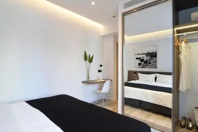 a bedroom with a king sized bed and a mirror at Poseidon Athens Hotel in Athens