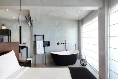 a bathroom with a large tub in a bedroom at Poseidon Athens Hotel in Athens