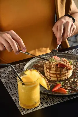 a person eating a plate of food with a waffle at Poseidon Athens Hotel in Athens