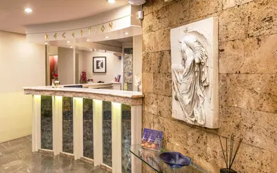 a stone wall with a sculpture on a wall at Ilisia Hotel Athens in Athens