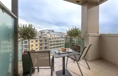 a balcony with a table and chairs and a view of a city at Ilisia Hotel Athens in Athens