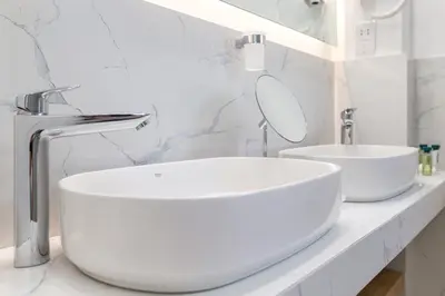 a white bathroom with a sink and a mirror at Ilisia Hotel Athens in Athens