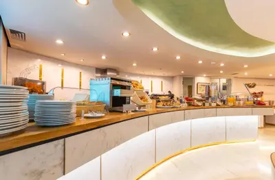 a large kitchen with white dishes on a counter at Ilisia Hotel Athens in Athens