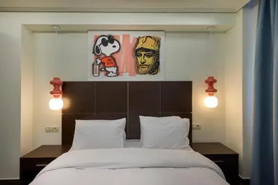 a bedroom with a bed and two paintings on the wall at Athens Way Pop Art Hotel in Athens