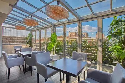 a restaurant with tables and chairs and a large glass ceiling at Athens Way Pop Art Hotel in Athens