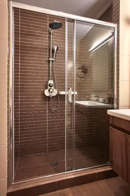 a shower with a glass door and a sink at Athens Way Pop Art Hotel in Athens