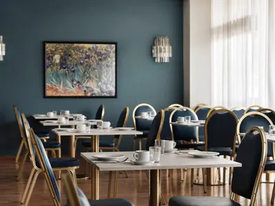 a dining room with tables and chairs and a painting on the wall at Candia Hotel in Athens