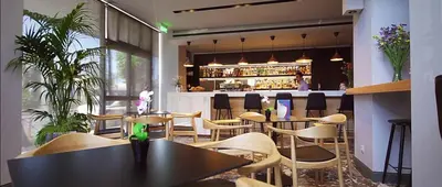 a restaurant with tables and chairs and a bar at Candia Hotel in Athens