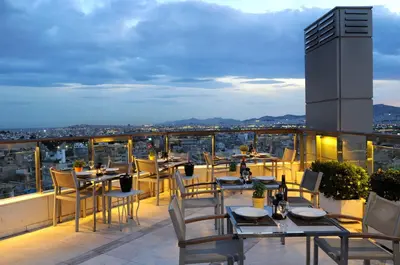 a restaurant with tables and chairs on a balcony at Dorian Inn - Sure Hotel Collection by Best Western in Athens