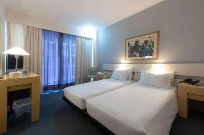 a hotel room with a large white bed and a desk at Dorian Inn - Sure Hotel Collection by Best Western in Athens