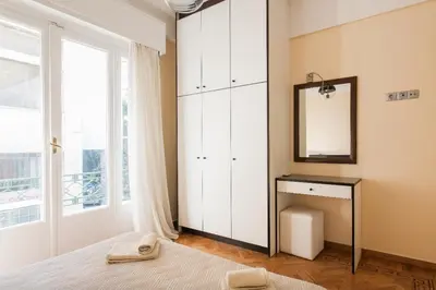a bedroom with a large white cabinet and a mirror at Beautiful Apartment at Plaka in Athens