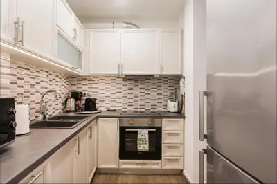 a kitchen with white cabinets and a refrigerator at Beautiful Apartment at Plaka in Athens