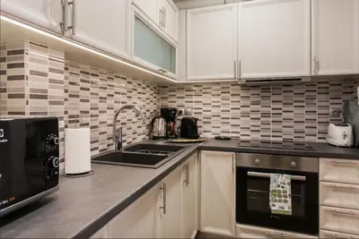 a kitchen with white cabinets and a sink at Beautiful Apartment at Plaka in Athens