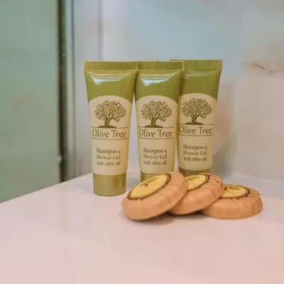 two bottles of olive tree products and three bananas on a counter at Chic Hotel in Athens