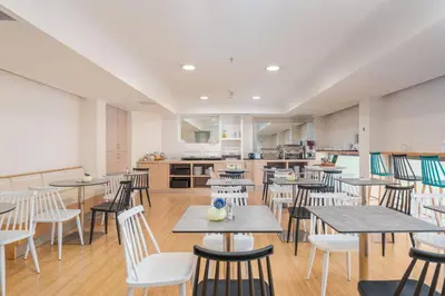 a restaurant with tables and chairs and a kitchen at Chic Hotel in Athens