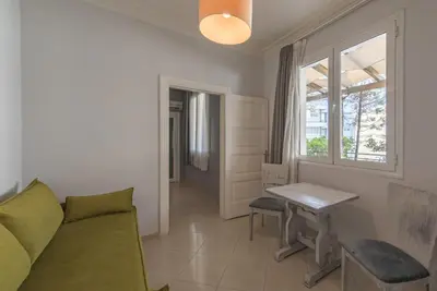 a living room with a couch and a table and a window at Kimon Hotel Athens in Athens