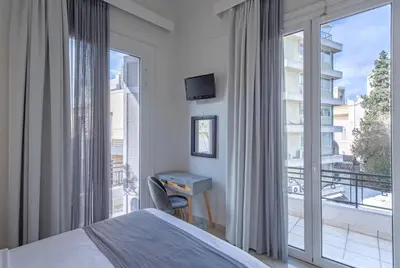 a bedroom with a bed and a large window at Kimon Hotel Athens in Athens