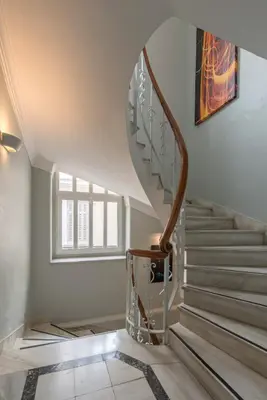 a staircase in a home with a spiral stair case at Kimon Hotel Athens in Athens