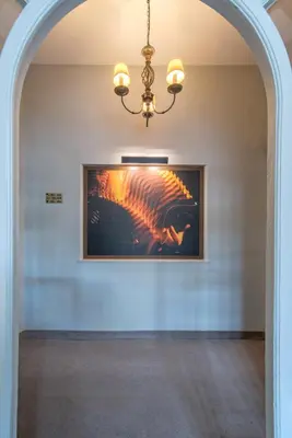 a hallway with a painting on the wall and a chandelier at Kimon Hotel Athens in Athens