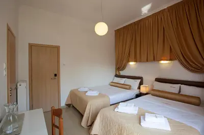 a hotel room with two beds and a table at Metropolis Hotel in Athens