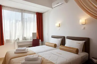a hotel room with two beds and a window at Metropolis Hotel in Athens