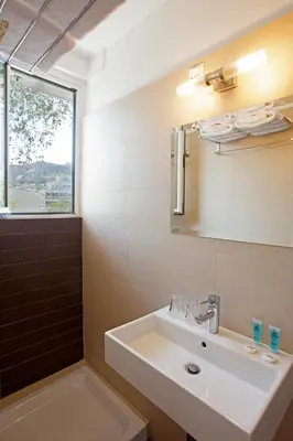 a bathroom with a sink and a window at Metropolis Hotel in Athens