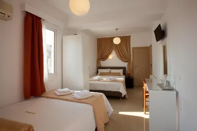 a hotel room with two beds and a table at Metropolis Hotel in Athens