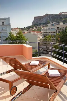 a balcony with a table and chairs on a roof at Metropolis Hotel in Athens