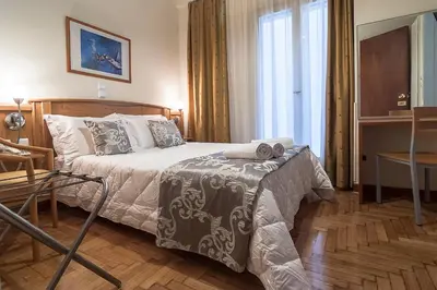 a bedroom with a bed and a table and a window at Ares Athens Hotel in Athens