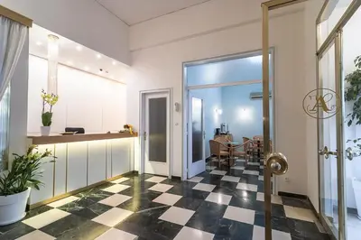a hallway with a checkered floor and a dining room at Ares Athens Hotel in Athens