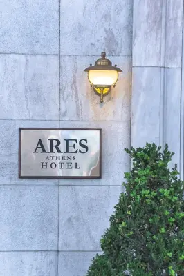 a sign on the side of a building with a light at Ares Athens Hotel in Athens