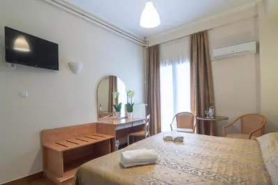 a bedroom with a bed and a desk and a mirror at Ares Athens Hotel in Athens