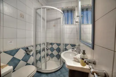 a bathroom with a shower and a toilet and a sink at Lagonisi Villa VIP in Lagonissi