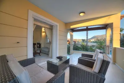 a patio with wicker chairs and a table at Lagonisi Villa VIP in Lagonissi