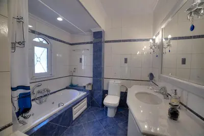a bathroom with a tub and a toilet and a sink at Lagonisi Villa VIP in Lagonissi