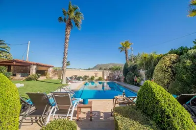a swimming pool in a yard with a palm tree at Lagonisi Villa VIP in Lagonissi