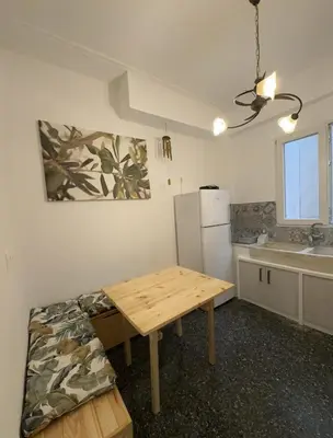 a kitchen with a wooden table and a refrigerator at Petaluda House 5 in Athens