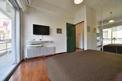 a bedroom with a bed and a flat screen tv at Architect Designer's Apartment in Kolonaki in Athens