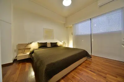 a bedroom with a bed and a large window at Architect Designer's Apartment in Kolonaki in Athens