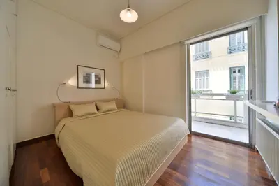 a bedroom with a bed and a large window at Architect Designer's Apartment in Kolonaki in Athens