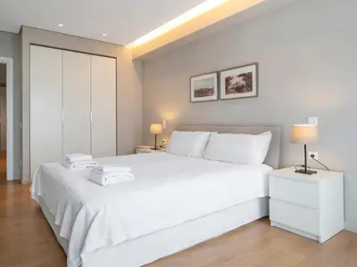 a white bedroom with a white bed and two lamps at Central Athens Loft in Athens