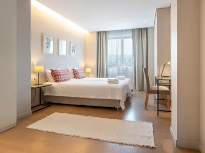 a bedroom with a white bed and a table and a window at Central Athens Loft in Athens