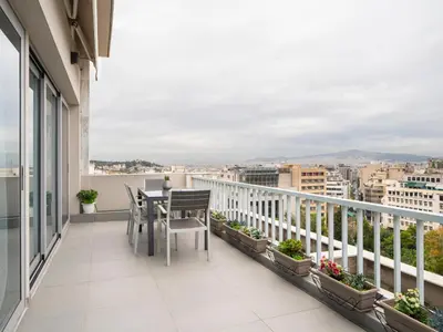 a balcony with a table and chairs on a building at Central Athens Loft in Athens