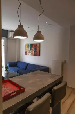 a living room with a table and a blue couch at Luxury 2 bdrm apartment 10' minutes walk from the Acropolis in Athens