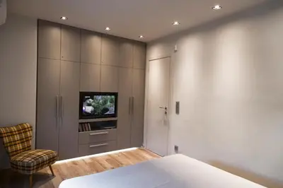 a bedroom with a bed and a chair and a tv at Luxury 2 bdrm apartment 10' minutes walk from the Acropolis in Athens