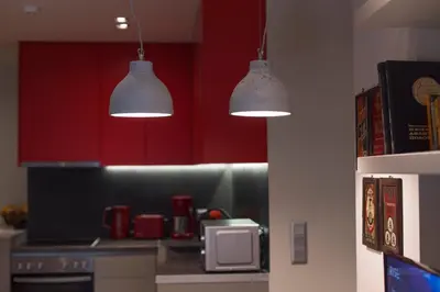 two lights hanging from a kitchen with red cabinets at Luxury 2 bdrm apartment 10' minutes walk from the Acropolis in Athens