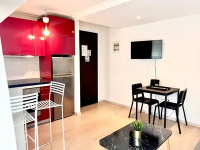 a kitchen and dining room with red cabinets and a table at Elvita Apartments in Athens