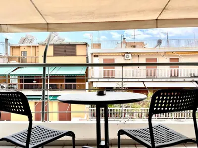a table and two chairs on a balcony with a view of a building at Elvita Apartments in Athens