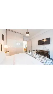 a bedroom with a large bed and a tv at Koukaki Home in Athens